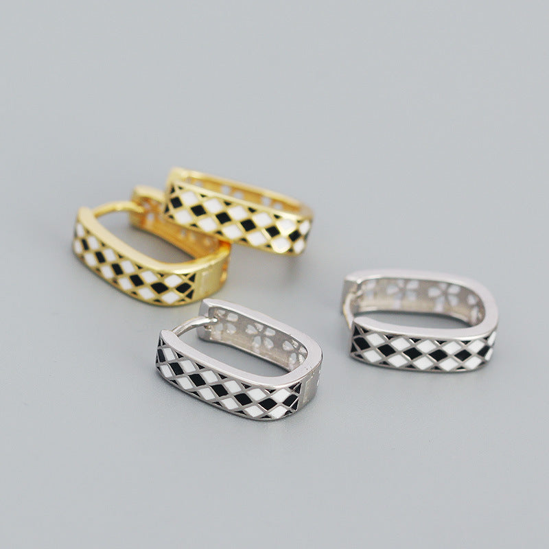 Detailed view of 15.2mm by 4.3mm chess board .925 sterling silver huggie hoop earrings showing engraved pattern and polished finish