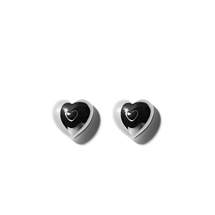 Detailed view of heart .925 sterling silver stud earrings showing delicate shape and polished finish