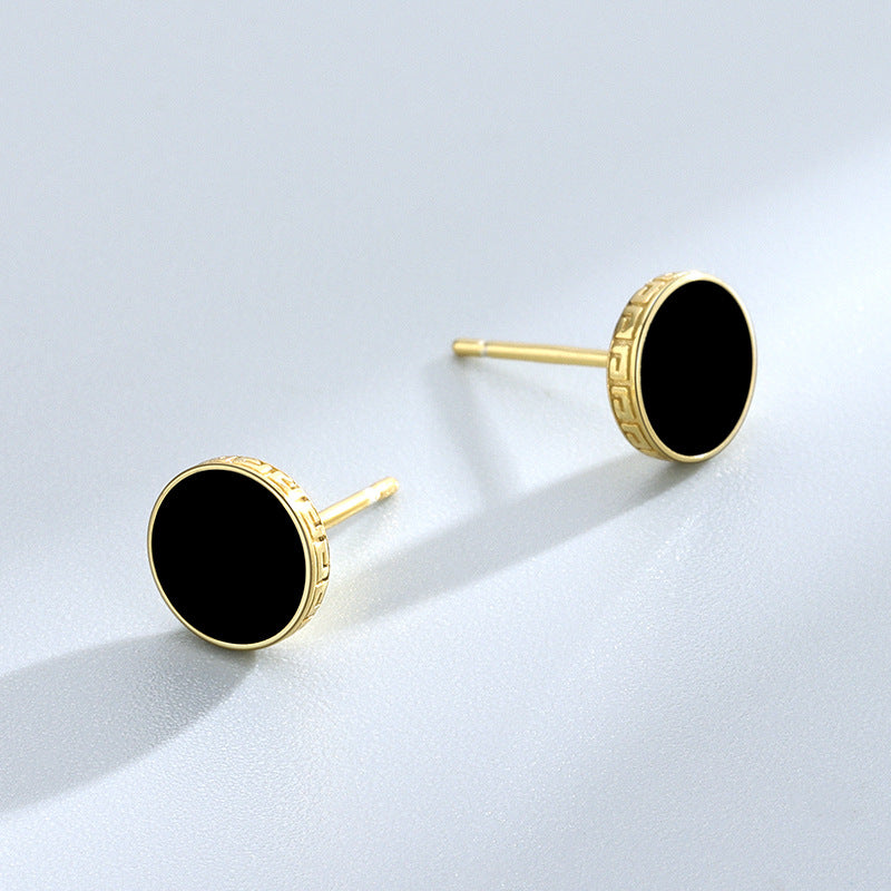 Detailed view of 7.8mm round .925 sterling silver black epoxy stud earrings showing smooth resin center and polished finish