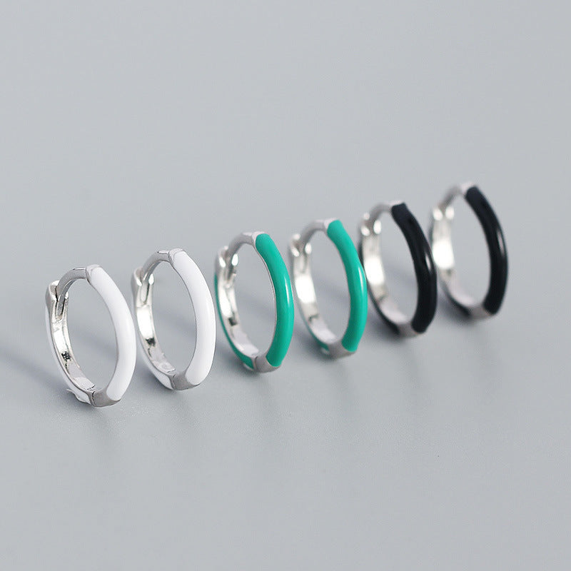 Detailed view of 12.6mm epoxy circle .925 sterling silver huggie hoop earrings showing smooth resin finish and polished silver