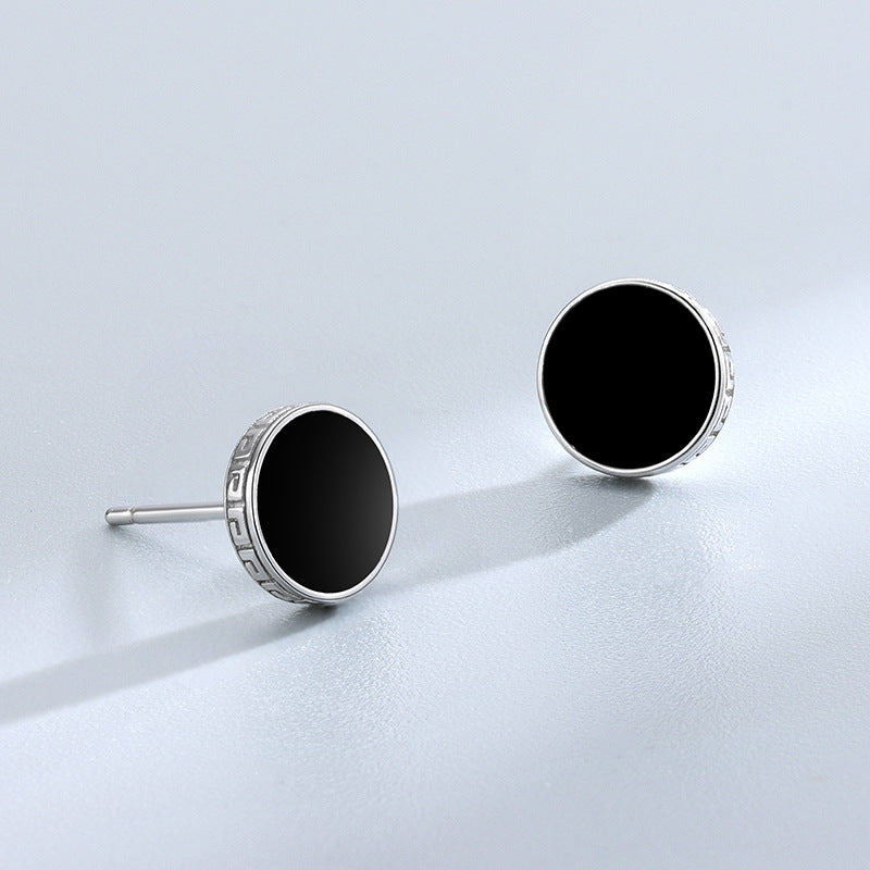 Detailed view of 7.8mm round .925 sterling silver black epoxy stud earrings showing smooth resin center and polished finish