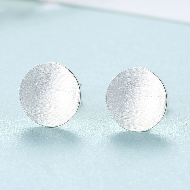 Detailed view of 9mm round .925 sterling silver stud earrings showing classic shape and polished finish