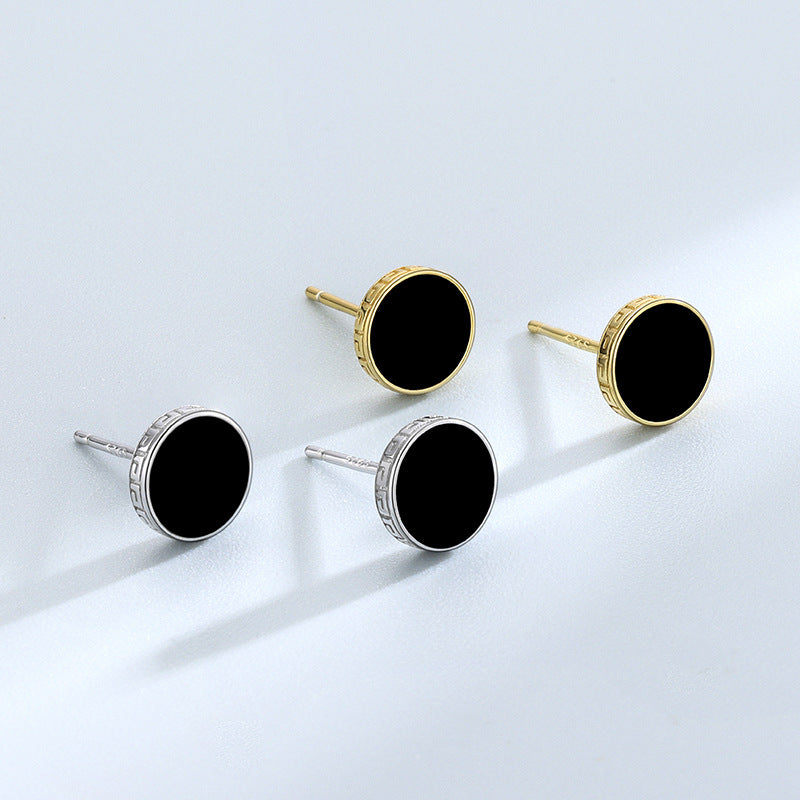 Detailed view of 7.8mm round .925 sterling silver black epoxy stud earrings showing smooth resin center and polished finish
