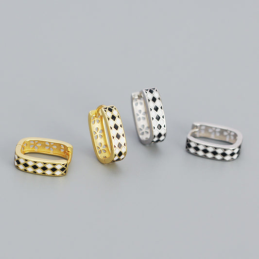 Detailed view of 15.2mm by 4.3mm chess board .925 sterling silver huggie hoop earrings showing engraved pattern and polished finish