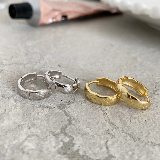 Detailed view of 7.3mm by 10.3mm etched circle .925 sterling silver hoop earrings showing engraved texture and polished finish