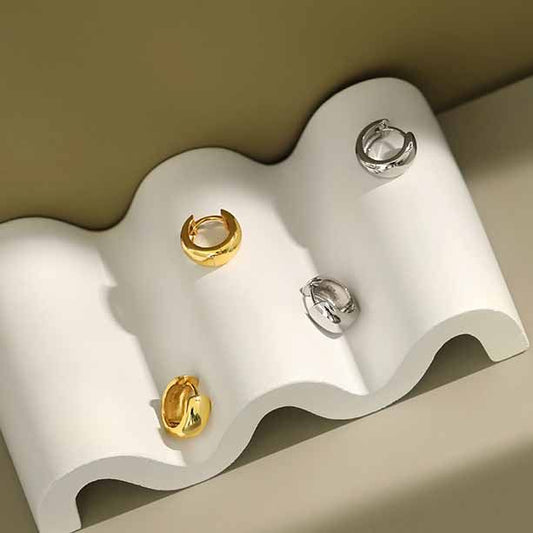 Detailed view of 10mm by 6.4mm mini circle sterling silver huggie hoop earrings showing polished finish.