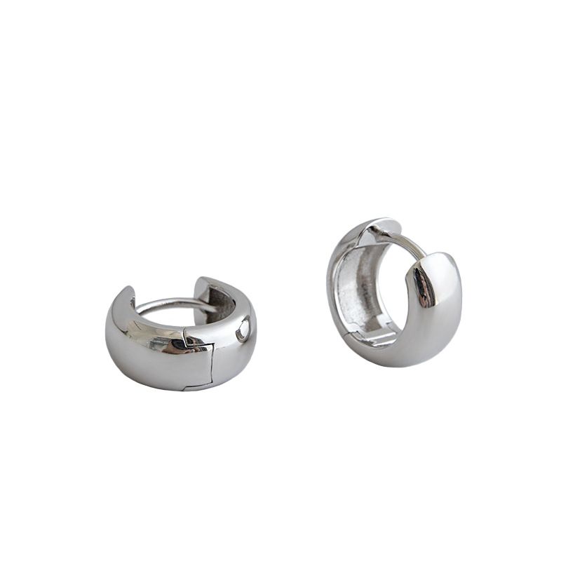 Detailed view of 10mm by 6.4mm mini circle sterling silver huggie hoop earrings showing polished finish