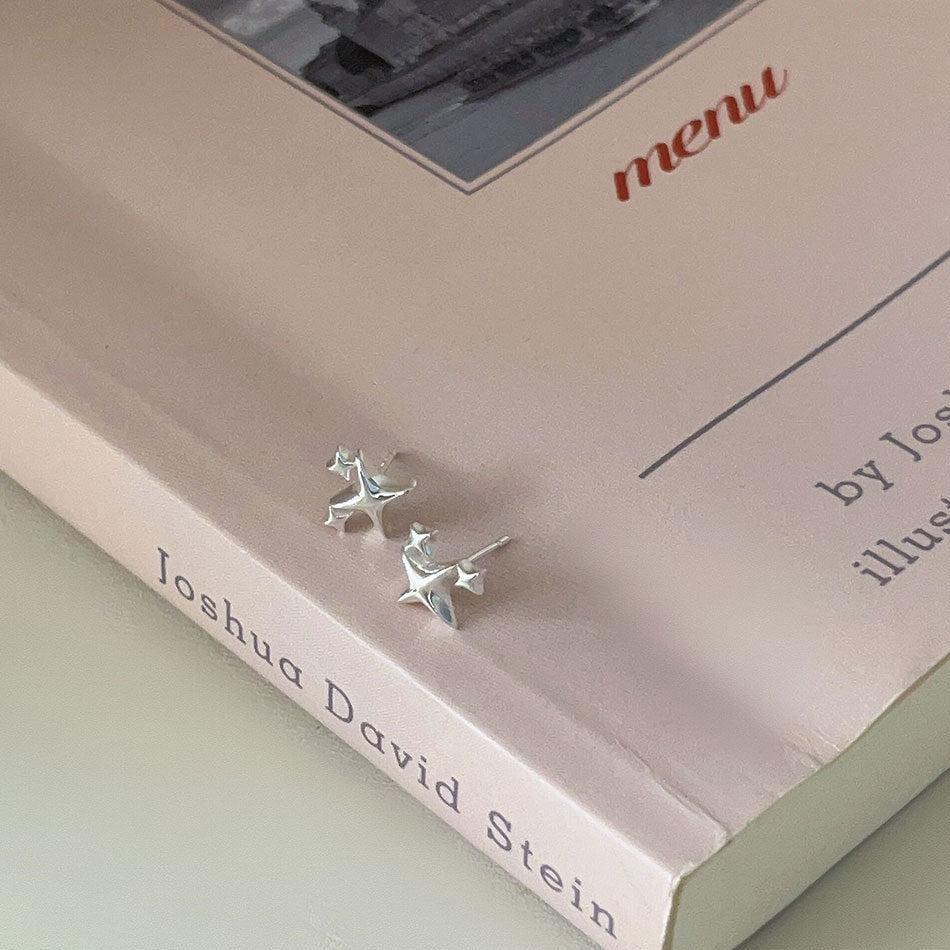 Detailed view of four pointed star .925 sterling silver stud earrings showing sharp geometric design and polished finish